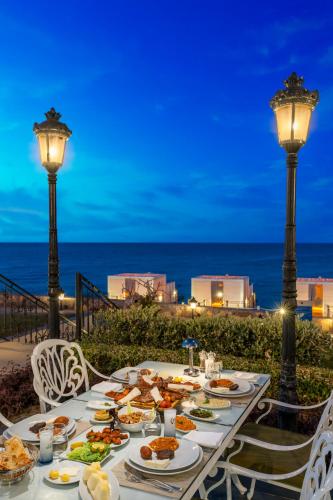a table with food on it with the ocean in the background at Kaya Palazzo Resort & Casino in Kérynia