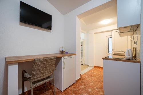 a kitchen with a refrigerator and a counter with a television at Villa Jadranka Sutomore in Sutomore