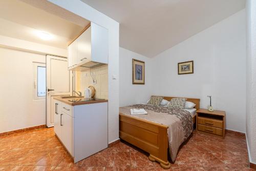 a small bedroom with a bed and a kitchen at Villa Jadranka Sutomore in Sutomore