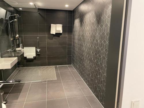 a bathroom with a shower and a sink at Hotel im LESKANPark in Cologne