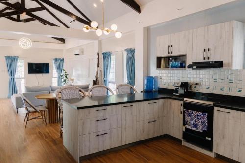 une cuisine avec des placards blancs et un comptoir noir dans l'établissement C-View Beach Resort, à Cantilan