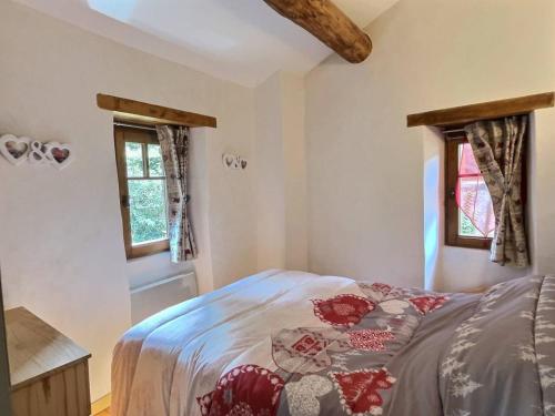 sypialnia z łóżkiem i 2 oknami w obiekcie L'Oustalet du Cagnel w mieście Valleraugue