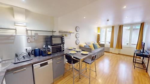 une cuisine et un salon avec une table et un canapé dans l'établissement Le Tonnelier Strasbourgeois - Strasbourg Cathédrale, à Strasbourg