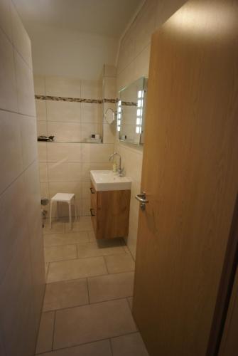 a bathroom with a sink and a mirror and a door at Beilsteiner Ferienwohnungen in Beilstein
