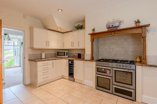 a kitchen with white cabinets and a stove top oven at Esk Valley House in Sleights