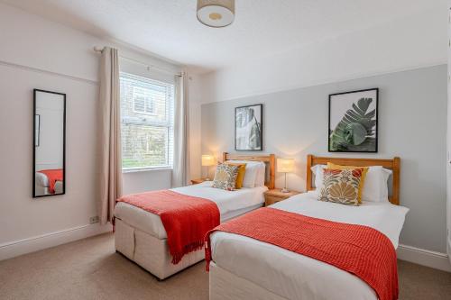 a bedroom with two beds and a window at Esk Valley House in Sleights