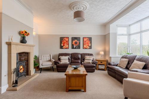 a living room with a couch and a fireplace at Esk Valley House in Sleights