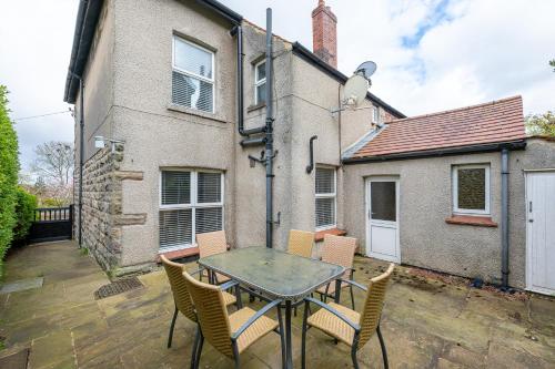 a patio with a table and chairs in front of a house at Esk Valley House in Sleights
