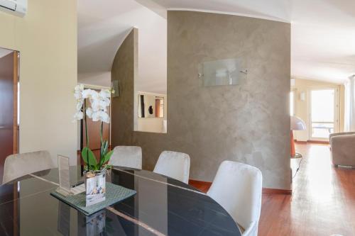 a dining room with a glass table and white chairs at Heart Milan Apartments San Sepolcro Duomo in Milan