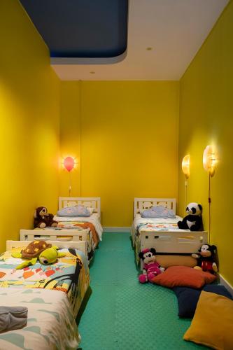 a room with three beds with stuffed animals on the floor at Kaya Palazzo Resort & Casino in Kérynia