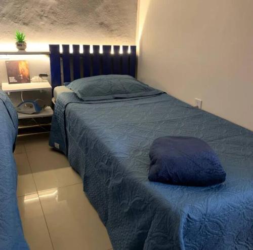 a bedroom with a bed with a blue comforter at Apartamento Com Piscina in Rio de Janeiro