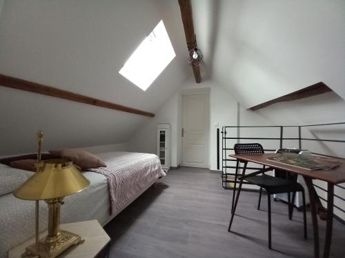Schlafzimmer mit einem Bett, einem Tisch und einem Fenster in der Unterkunft gite de la tour carrée in Montrichard