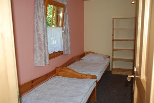 two beds in a room with a window at Ferienwohnung Lahnerhof in Arriach