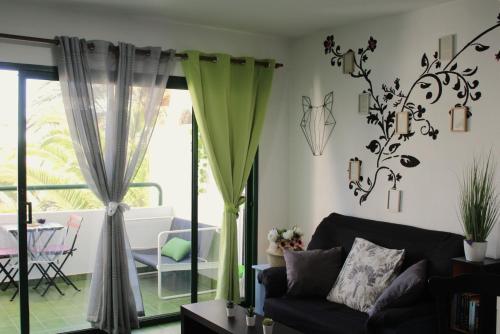 een woonkamer met een bank en een tafel bij Surycan Tropical Garden Apartment in Playa del Inglés