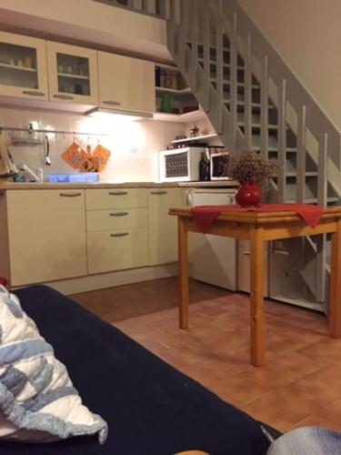 une cuisine avec une table et une cuisine avec un escalier dans l'établissement Bel appart vue mer proche centre, climatisation, à Saintes-Maries-de-la-Mer