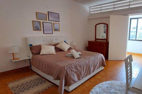 a bedroom with a large bed and a mirror at Pet friendly T1 sossegado c/ pátio espaçoso in Luanda