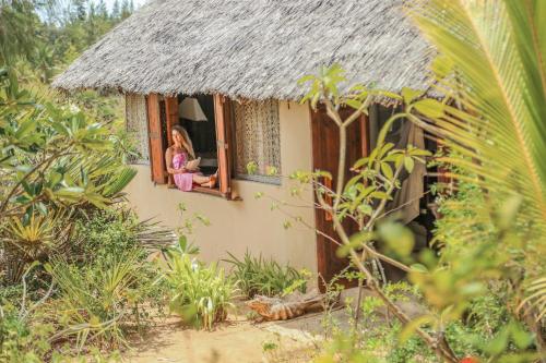 a little girl sitting in a window of a house at The Cabanas Lamu in Lamu