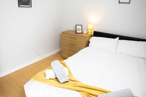 a bedroom with a white bed and a wooden dresser at Central 2 Bed Flat - Leeds City Centre - For Relocatlors, Professionals in Leeds