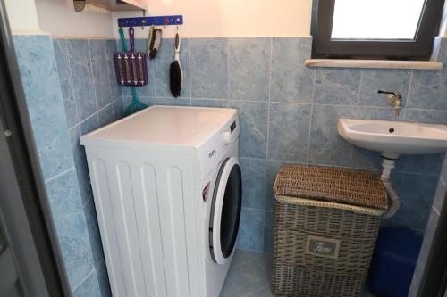 a bathroom with a washing machine and a sink at Toni Apartment Berat in Berat