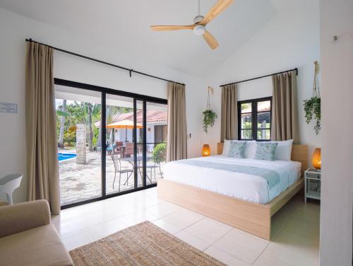 a bedroom with a bed and a sliding glass door at Garden By The Sea in Sosúa
