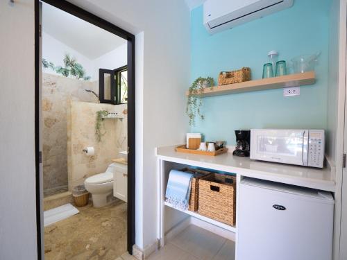 a bathroom with a sink and a toilet and a mirror at Garden By The Sea in Sosúa