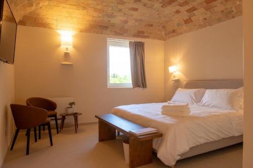 a bedroom with a bed with a table and a window at Moliké country house in Giulianova