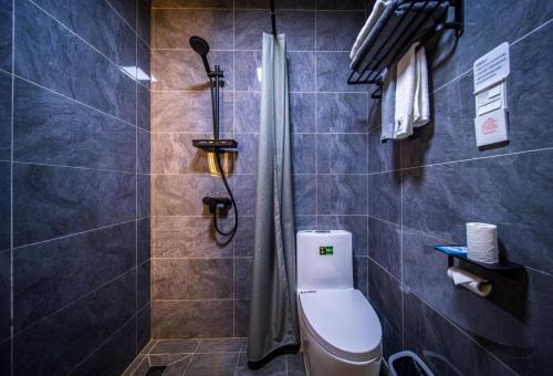 a bathroom with a toilet and a shower at 八达岭诚苑民宿 in Xibozi