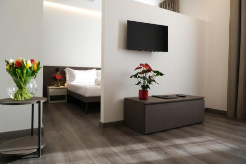 a living room with a couch and a tv on a wall at Emerald Green Residence in Caldiero