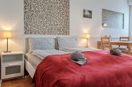 ein Schlafzimmer mit einem roten Bett mit zwei Handtüchern darauf in der Unterkunft Astoria Apartment in Budapest