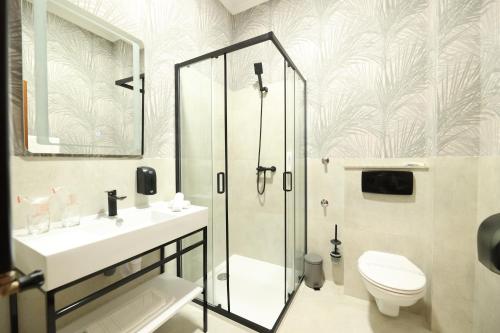 a bathroom with a shower and a toilet and a sink at Hotel Vidović in Banja Luka