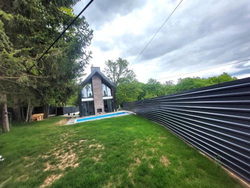 an open fence in front of a house at Orange Villa with private pool in Ilidza