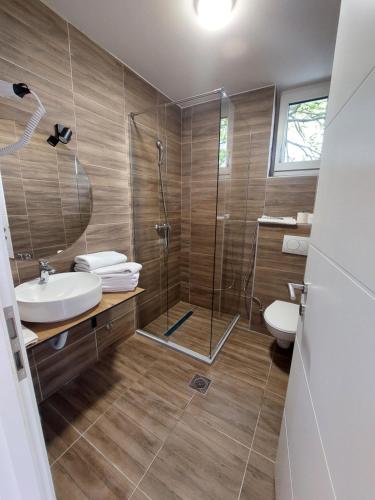 bagno con doccia, lavandino e servizi igienici di Orange Villa with private pool a Ilidža