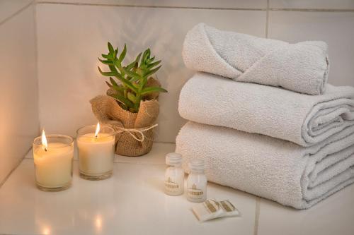 a bathroom with candles and towels and a plant at Embajador Hotel in Buenos Aires