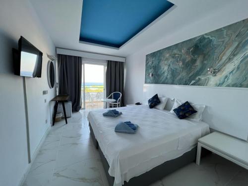 1 dormitorio con 1 cama grande y techo azul en Adelais Bay Hotel en Protaras