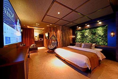 a bedroom with a large bed and a large screen at Hotel Vanilla Komaki (Adult Only) in Komaki