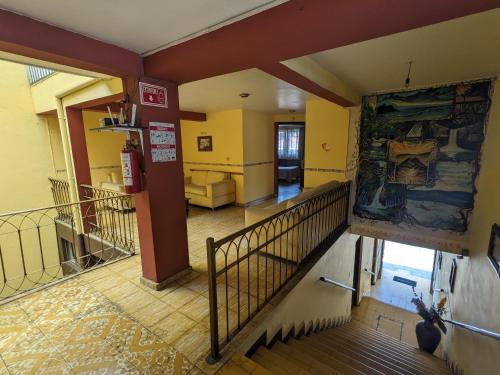 a hallway with a staircase in a building with a painting on the wall at Hotel del Parque in Uruapan del Progreso