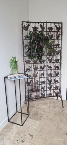 a metal rack with a table and a plant at Hotel Des Zouaves in Koksijde