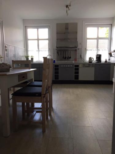 a kitchen with a table and chairs and a stove at Ferienwohnung Adolfshof EG in Malente