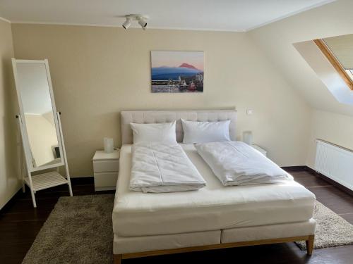 ein weißes Bett mit weißen Kissen in einem Zimmer in der Unterkunft Troll's Brauhaushotel in Medebach