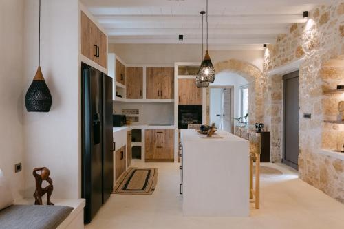 a kitchen with a white refrigerator and wooden cabinets at Villa Aldea - Luxury Boho Style in Melidhónion