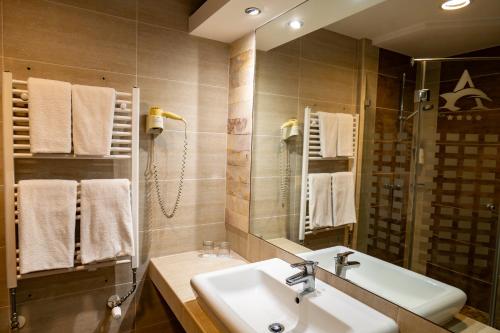 a bathroom with a sink and a mirror at Hotel Atlantis Medical, Wellness & Conference in Hajdúszoboszló