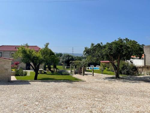 a gravel parking lot with trees and a building at Casa da Maravilhas in Viana do Castelo