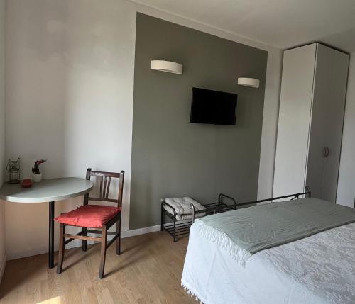 1 dormitorio con cama, mesa y TV en B&B La Lanterna, en Verbania