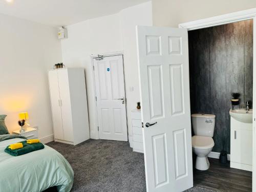 ein Schlafzimmer mit einem Bett und einem WC in der Unterkunft Manzil by HeyHouseLife in Middlesbrough