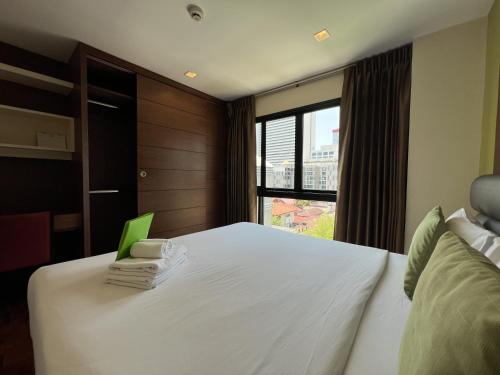 a bedroom with a white bed and a window at Silom Forest Exclusive Residence in Bangkok
