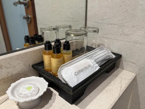 a tray with bottles of oils on a counter in a bathroom at Silom Forest Exclusive Residence in Bangkok