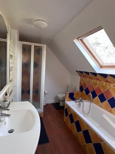 ein Badezimmer mit einem Waschbecken und einer Badewanne in der Unterkunft Maison POL Amboise in Amboise