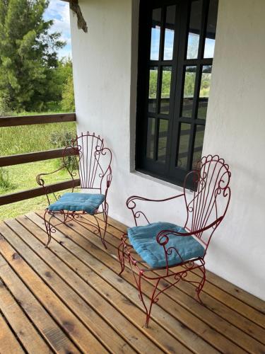 two chairs sitting on a porch with a window at El Garzal in Mercedes