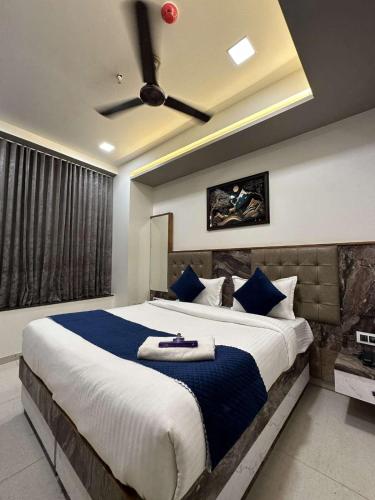 - une chambre avec un grand lit et un ventilateur de plafond dans l'établissement HOTEL E CLASSICO, à Bhavnagar