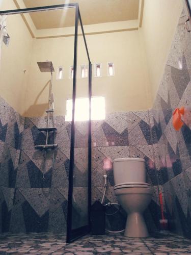 a bathroom with a toilet and a shower at Ridho's Homestay & Jungle Trekking in Bukit Lawang